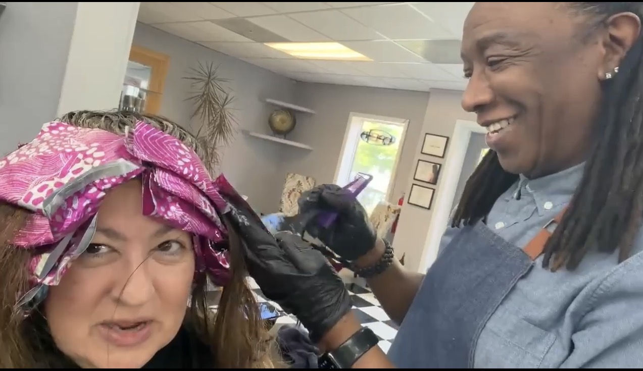 Stylist applying soft brunette hair color with face-framing highlights at Salon International in Charleston SC